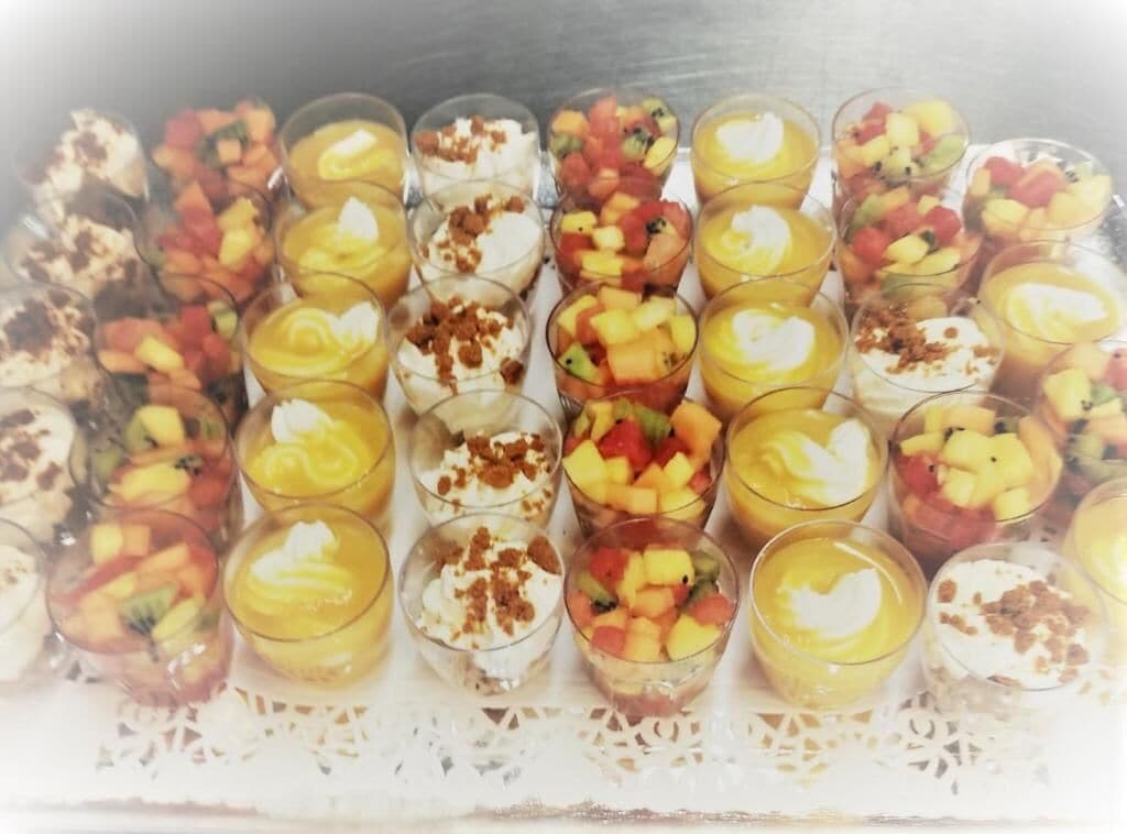 Une barquette de parfaits aux fruits présentés dans des verres transparents.
