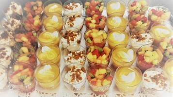 Une barquette de parfaits aux fruits présentés dans des verres transparents.