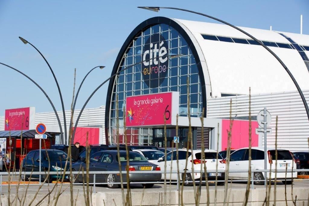 Un edificio moderno con una vasta facciata in vetro e un cartello ben visibile con la scritta 'cite europe'.