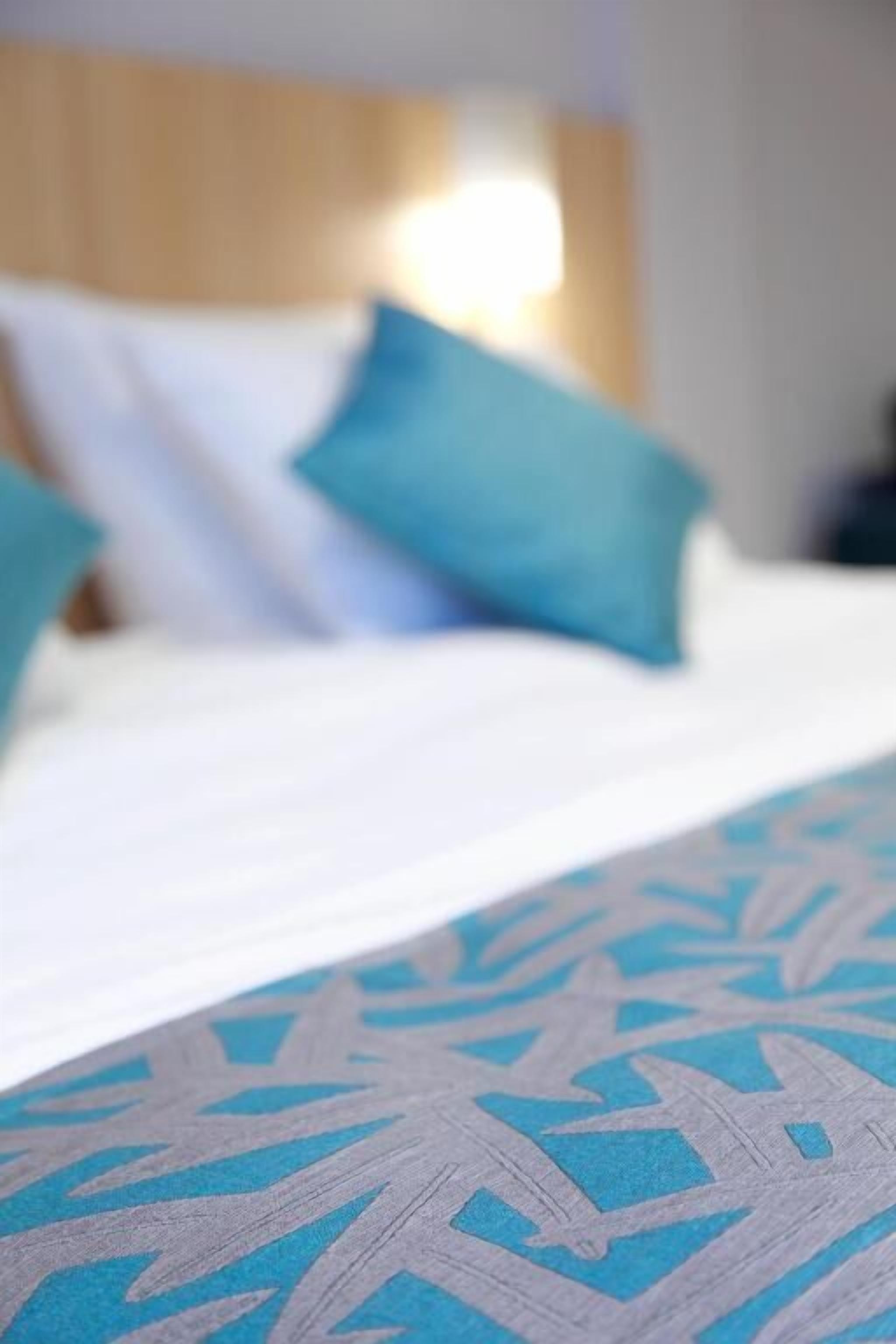 Una cama con una colcha y almohadas estampadas.