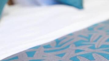 Uma cama com colcha e almofadas estampadas.