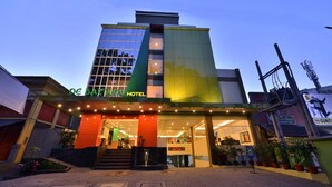 A hotel with a modern facade, large windows, and a well-lit entrance. - De Batara Hotel (Bandung)
