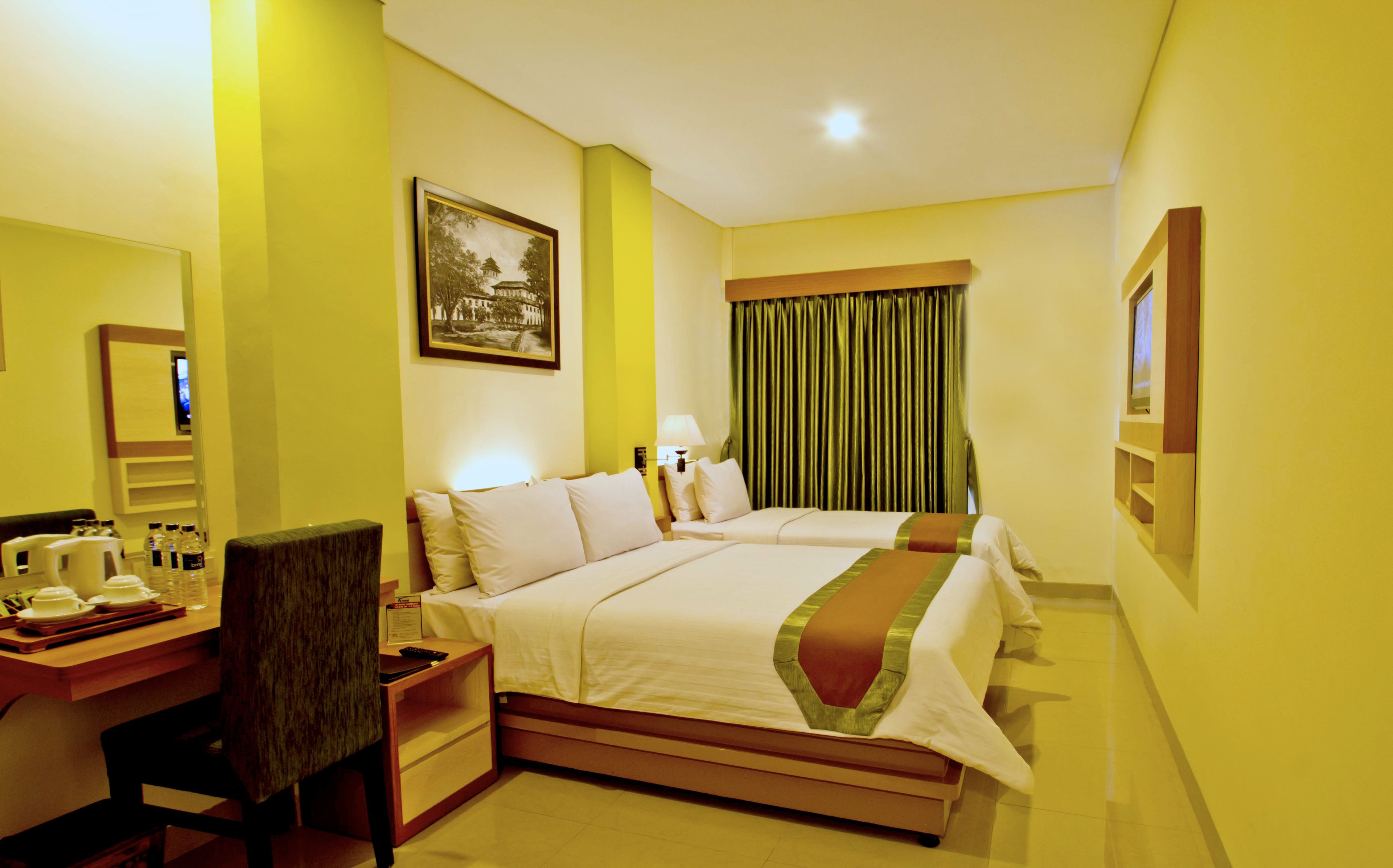Una habitación de hotel con cama, mesita de noche, lámpara y escritorio con silla.
