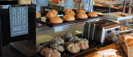 A bakery display with various types of bread and pastries.