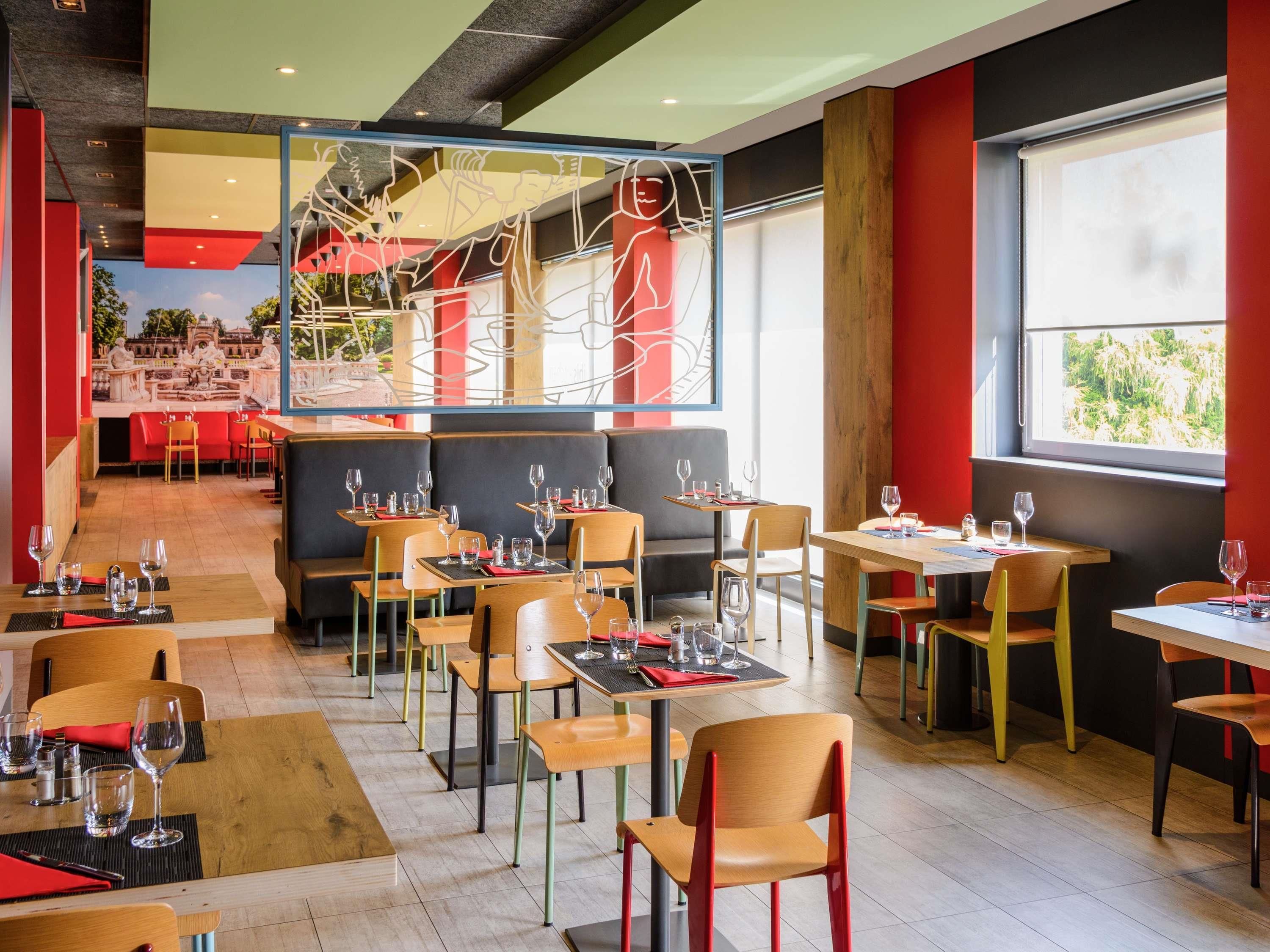 A restaurant interior with tables and chairs, a large window, and a view of the outdoors.