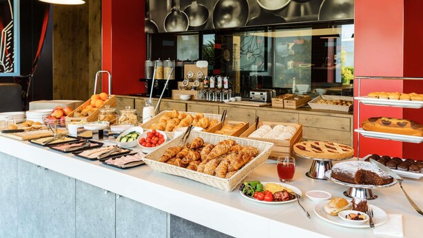 A buffet with various food items and a coffee station. - Ibis Milano Fiera (Lainate)