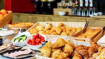 Indulge in a diverse spread of fresh bread, sliced meats, and seasonal produce at our buffet.