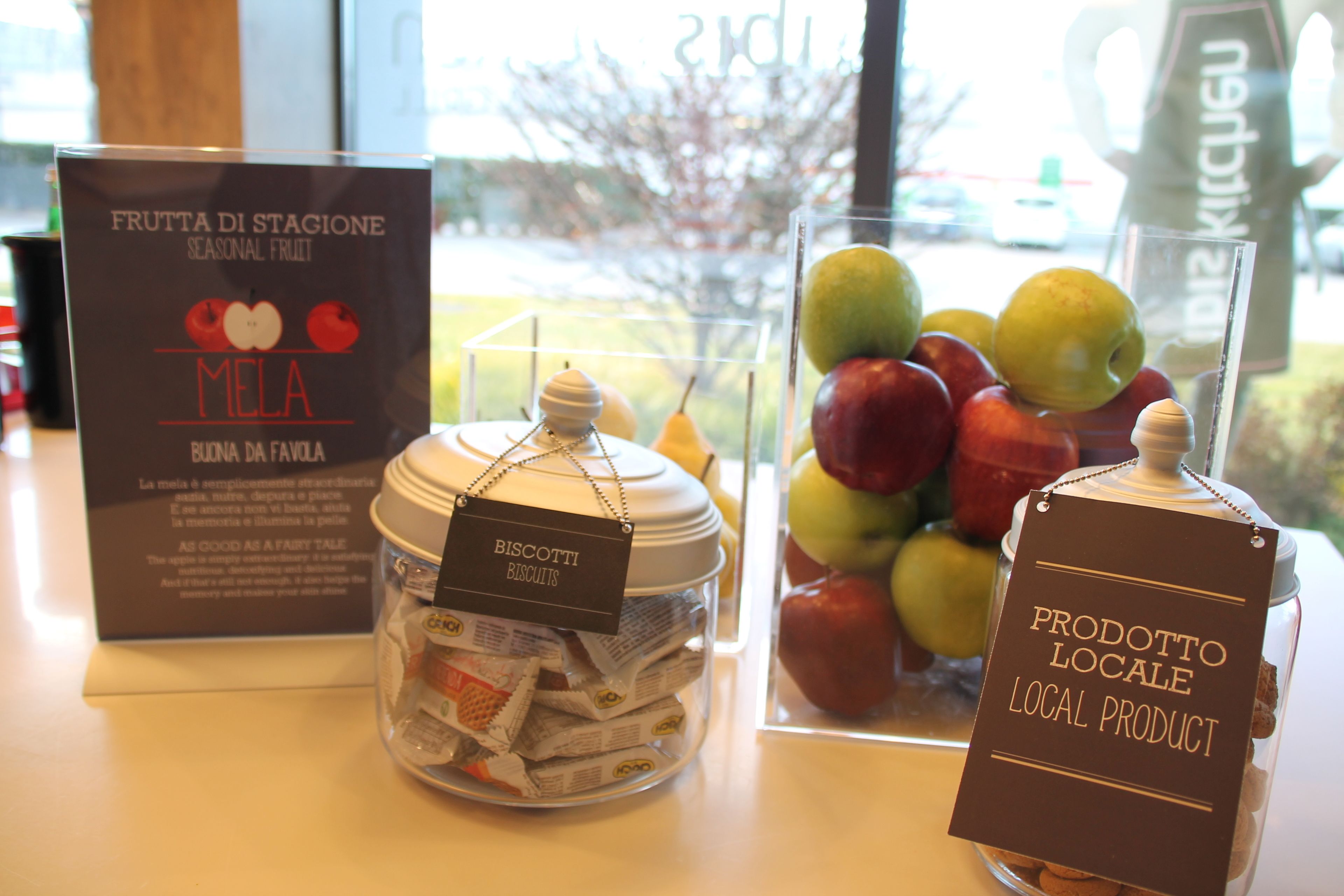 A display of seasonal fruits, biscotti, and local products in a store.