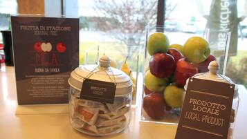 A display of seasonal fruits, biscotti, and local products in a store.