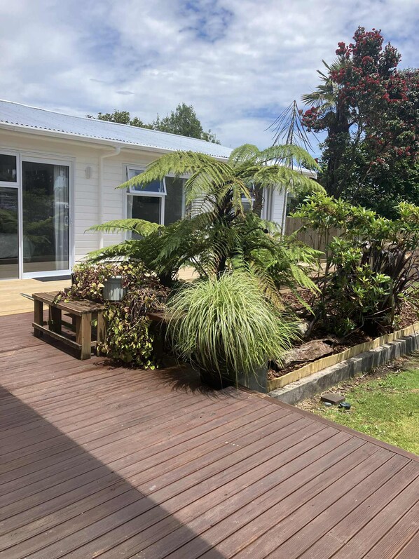 A wooden deck with a house in the background. - TripInn Modern Motels & Affordable Accommodation (Westport)
