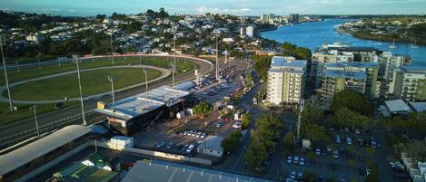 Un paisaje urbano costero con un puerto deportivo, un estadio y un hotel llamado 'Quest'.