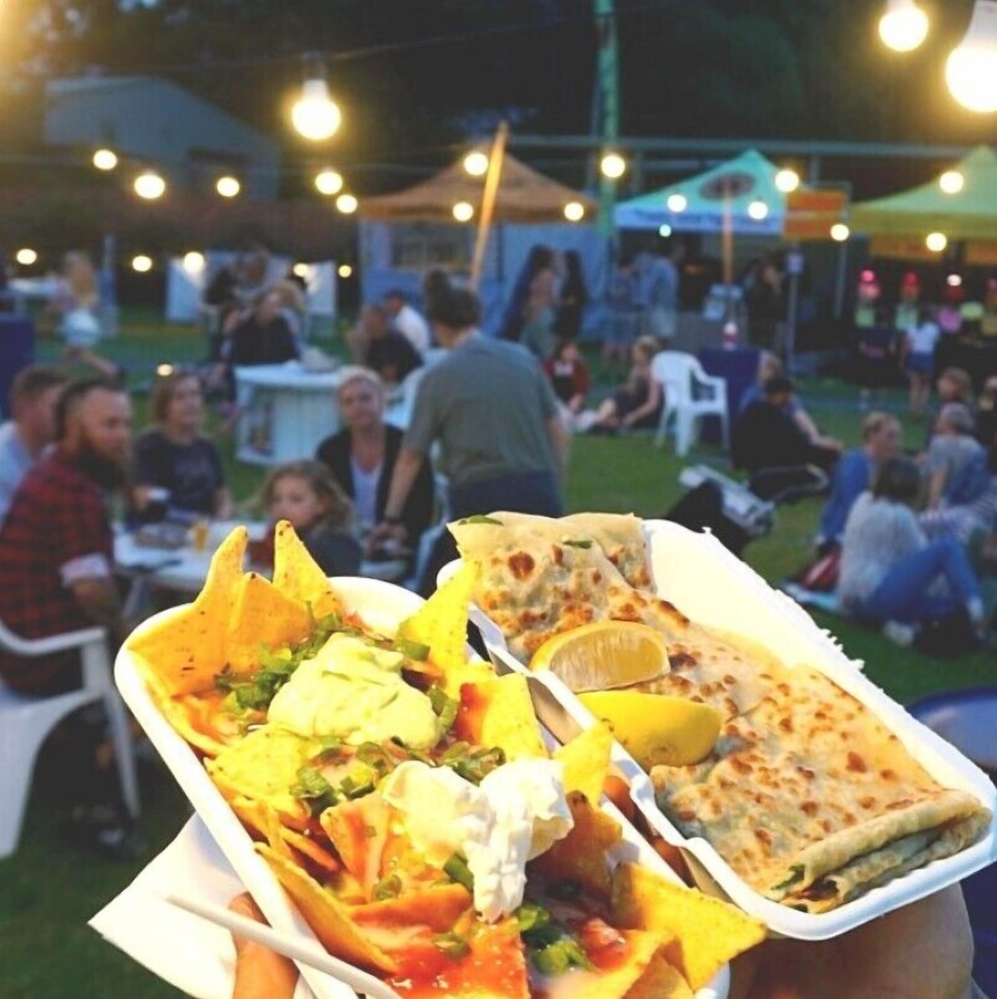 A food stall at an outdoor event with nachos and flatbread.