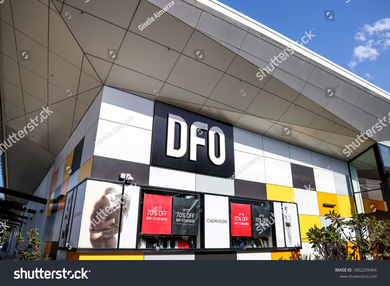 Un magasin DFO doté d’une façade moderne, avec de grandes vitrines et des panneaux publicitaires annonçant des réductions allant jusqu’à 70 %.