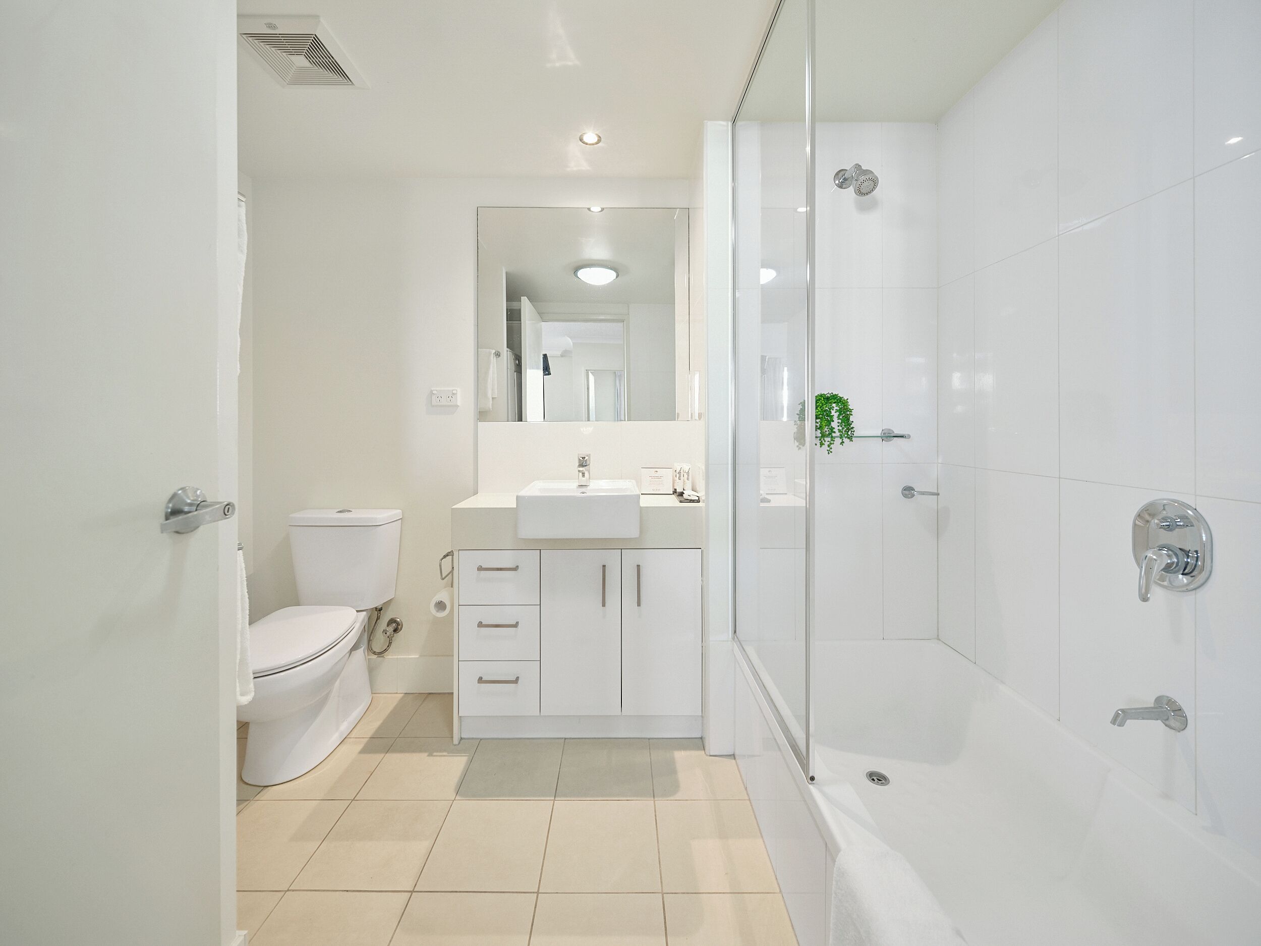 A modern bathroom with a toilet, sink, and shower area.