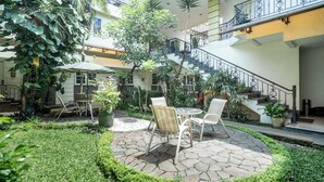 A courtyard with a stone patio, outdoor furniture, and potted plants.