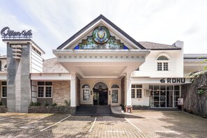 A hotel entrance with a prominent sign, a covered entrance, and a parking area. - Rehat at Ottenville Boutique Hotel (Bandung)