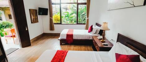 A hotel room with two beds, a window with curtains, a flat-screen TV, and a painting on the wall.