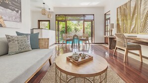 Una sala de estar moderna con sofá, mesa de centro y comedor.