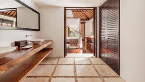 A modern bathroom with a wooden vanity, two sinks, and a large mirror. - The Pavilions Bali (Denpasar)