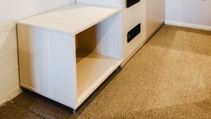 A room with a built-in desk, wardrobe, and an air conditioning unit. - Balan Village Motel (Bomaderry)