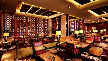 A spacious lobby with multiple seating areas, including sofas and armchairs, arranged around a central coffee table.