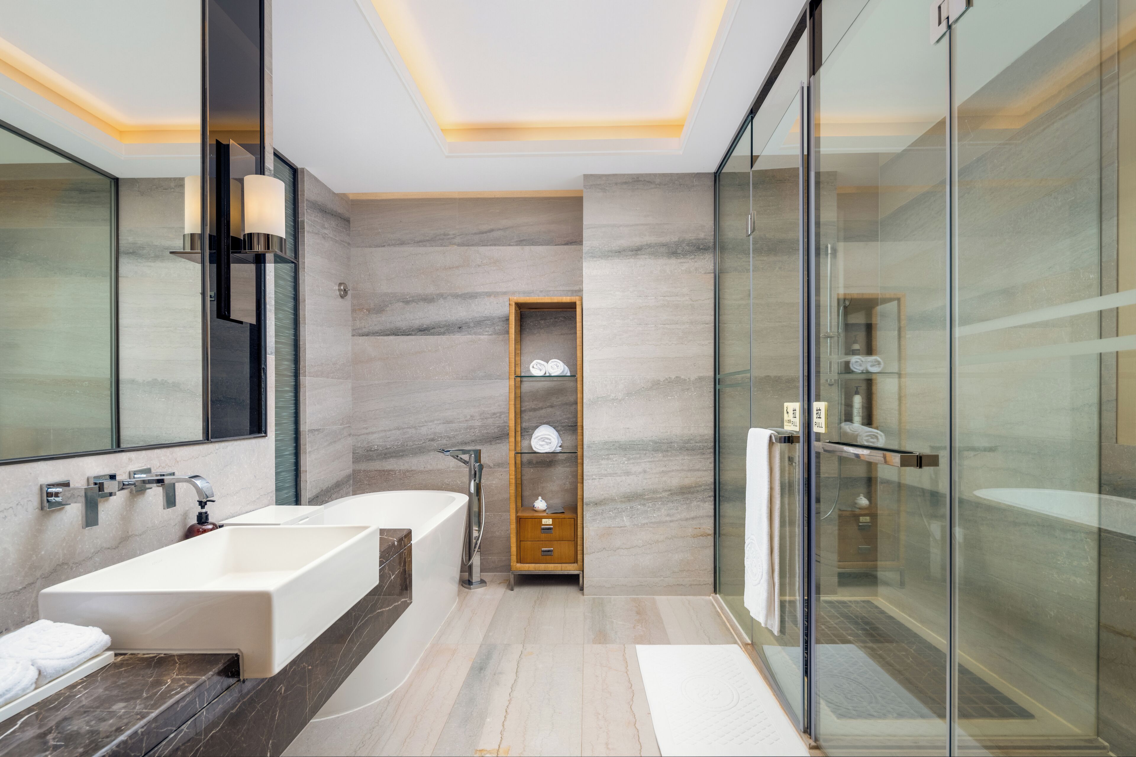 A modern bathroom with a large bathtub, a separate shower area, and a glass-enclosed walk-in shower.