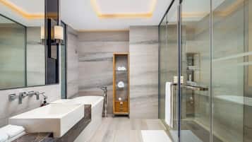 A modern bathroom with a large bathtub, a separate shower area, and a glass-enclosed walk-in shower.