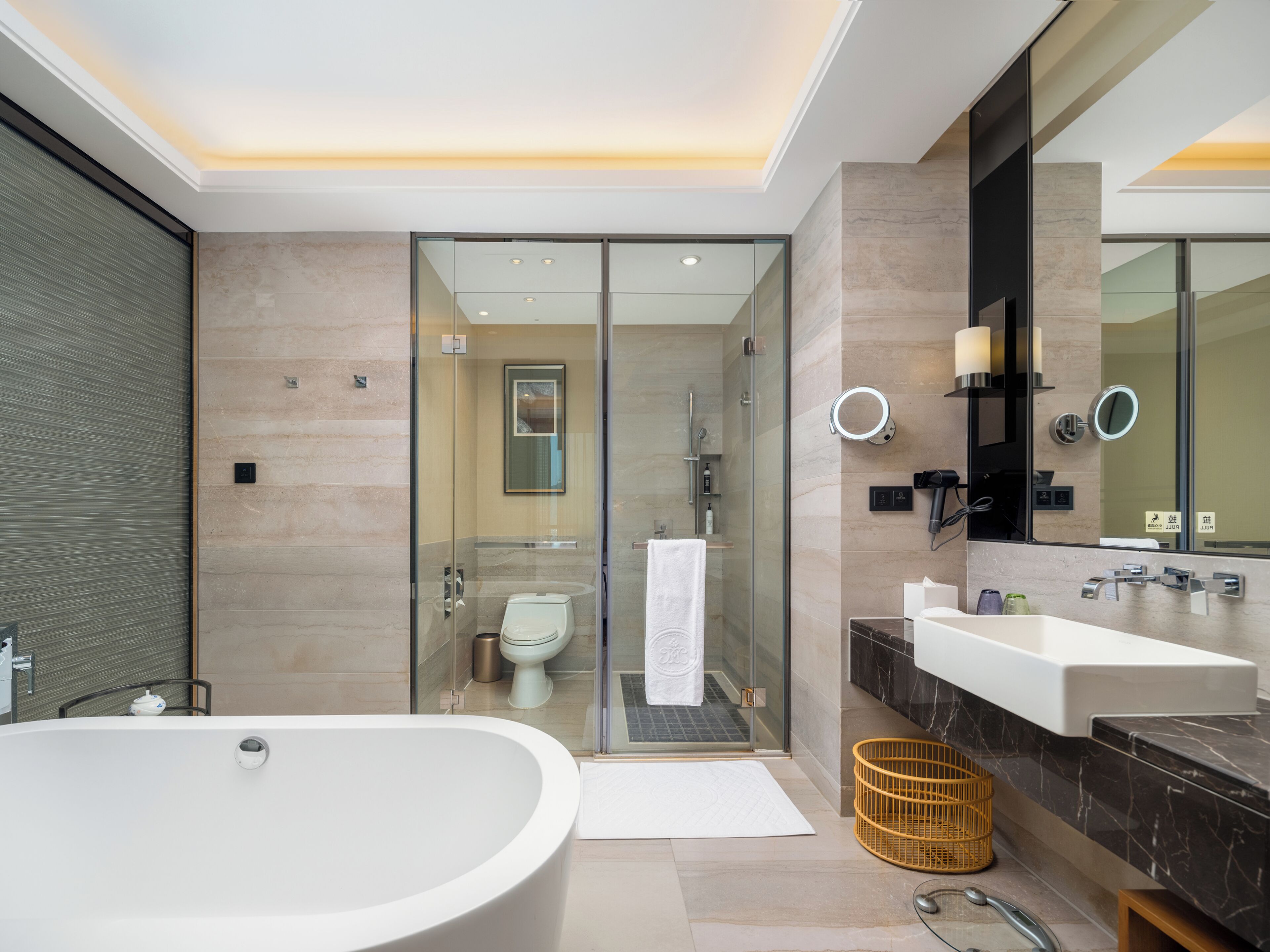 A modern bathroom with a large bathtub, a glass-enclosed shower, and a vanity with a mirror.
