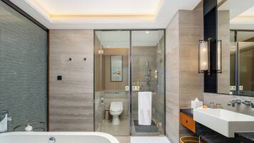 A modern bathroom with a large bathtub, a glass-enclosed shower, and a vanity with a mirror.