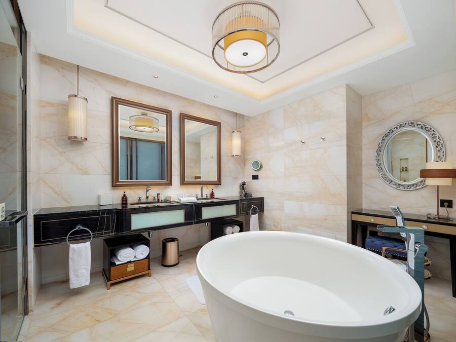 A modern bathroom with a freestanding bathtub, dual sinks, and large mirrors.