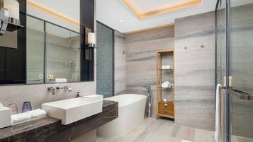 A modern bathroom with a large bathtub, a vanity with two sinks, and a glass shower enclosure.