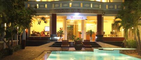 Alberca al aire libre, sombrillas en la alberca y camastros