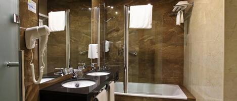 Un baño moderno con dos lavamanos, ducha y bañera.