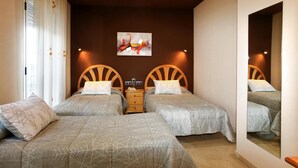 Un dormitorio con dos camas, cabeceros de madera, una mesita de noche y una obra de arte colgada en la pared.