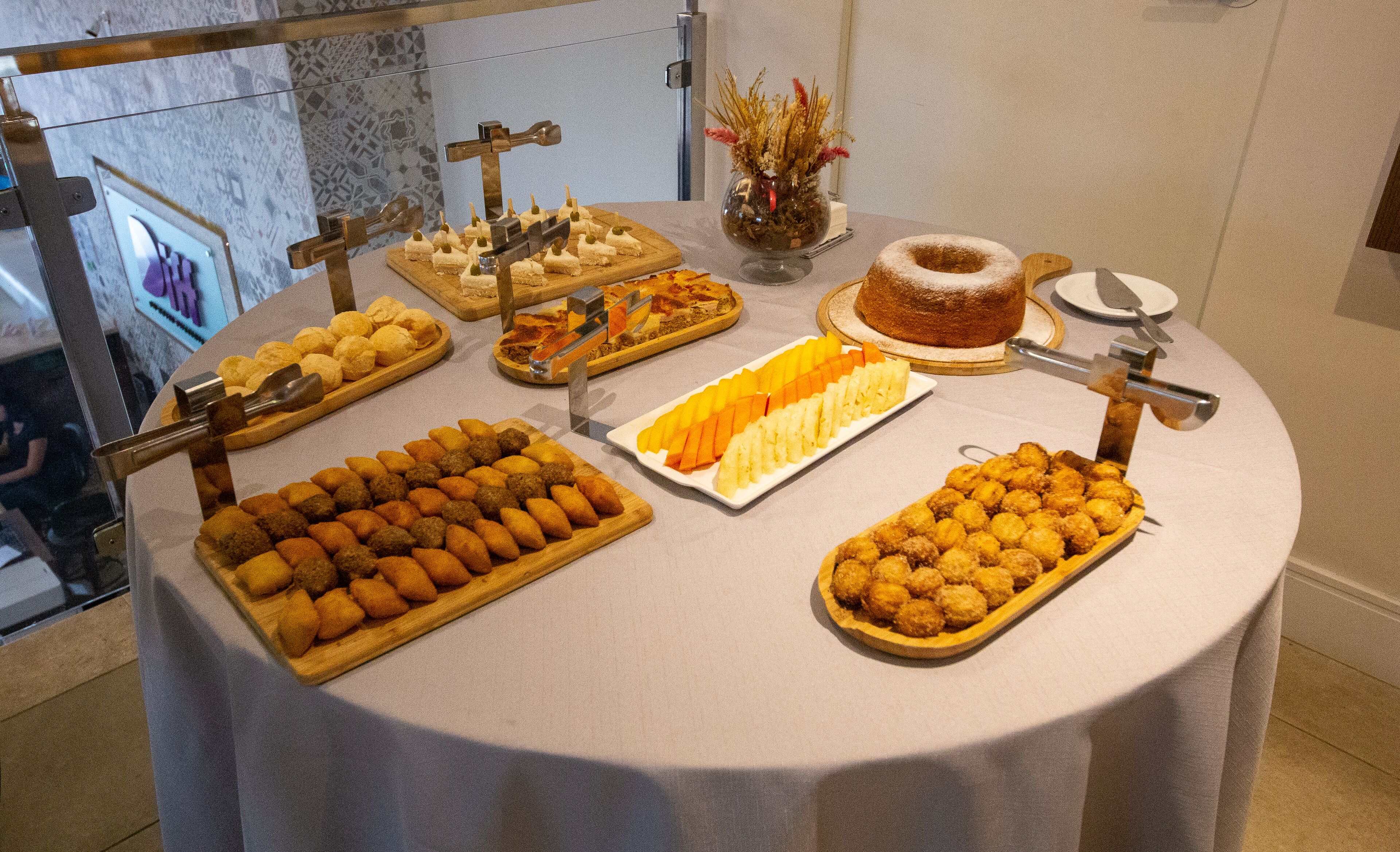Una mesa de buffet con diversos alimentos, como pasteles, frutas y un pastel.