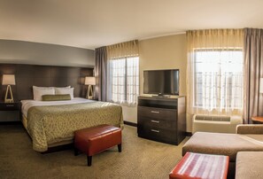 A hotel room with a bed, a television, a desk, and a chair. - Staybridge Suites Schererville by IHG (Schererville)