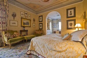 A classic bedroom with a large bed, a green sofa, and a small table. - Villa Michaela (Capannori)