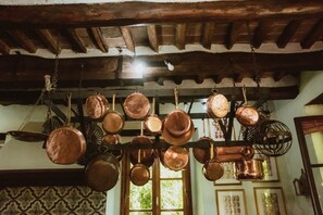 A kitchen with copper pots hanging from the ceiling. - Villa Michaela (Capannori)