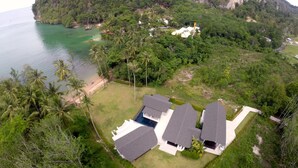 A coastal property with multiple buildings, a beach, and dense greenery. - The Beach House (Krabi)