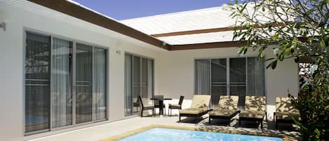 Een buitenzwembad, parasols bij het zwembad en ligstoelen