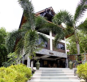 A two-story house with a stone facade, large windows, and a balcony. - Thara Bayview Villa (Krabi)