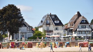 Une propriété située en bord de mer, dotée d’une architecture traditionnelle, d’une plage de sable et de divers équipements à proximité de la plage.