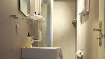 Une petite salle de bain comprenant un lavabo, des toilettes et une douche.
