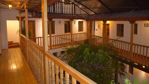 A wooden balcony with a railing, a staircase, and a view of the interior space. - Huascaran Casa Boutique Cusco (Cusco)
