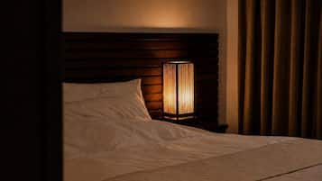 Ein Bett mit Kopfteil, einer Nachttischlampe und einem Vorhang.