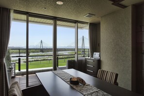 A modern hotel room with a large window offering a view of a bridge and river. - Tokachigawa Onsen Daiichi Hotel Hoshutei Toyotei (Otofuke)