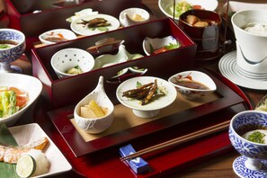 A traditional Japanese meal setup with various dishes and utensils on a tray. - Tokachigawa Onsen Daiichi Hotel Hoshutei Toyotei (Otofuke)