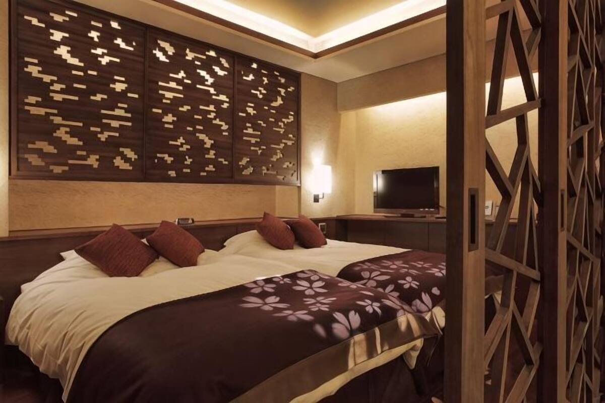 Une chambre d’hôtel avec un grand lit, une télévision et un panneau décoratif au mur.