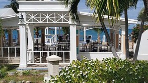 A white gazebo with a roof supported by columns, surrounded by lush greenery and a clear blue sky. - Bungalows on the Bay (Christiansted)