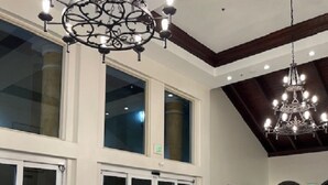 A spacious lobby with a high ceiling, large windows, and a grand chandelier. - Shores of Panama Beach Resort (Panama City Beach)